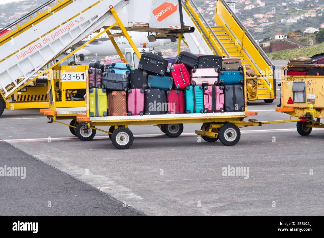 Ein Gepäckwagen mit Koffer und Taschen für Reisende, die auf den Transfer zum Flughafenterminal warten, um sie abholen zu können. Stockfoto