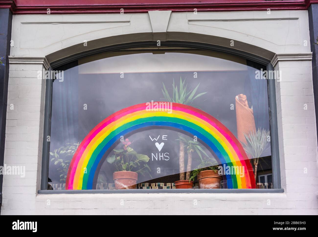 Ein Fenster mit einem Regenbogen und dem Zitat "wir lieben NHS", das die Hoffnung während der Coronavirus Pandemie im März 2020, Southampton, England, Großbritannien symbolisiert Stockfoto