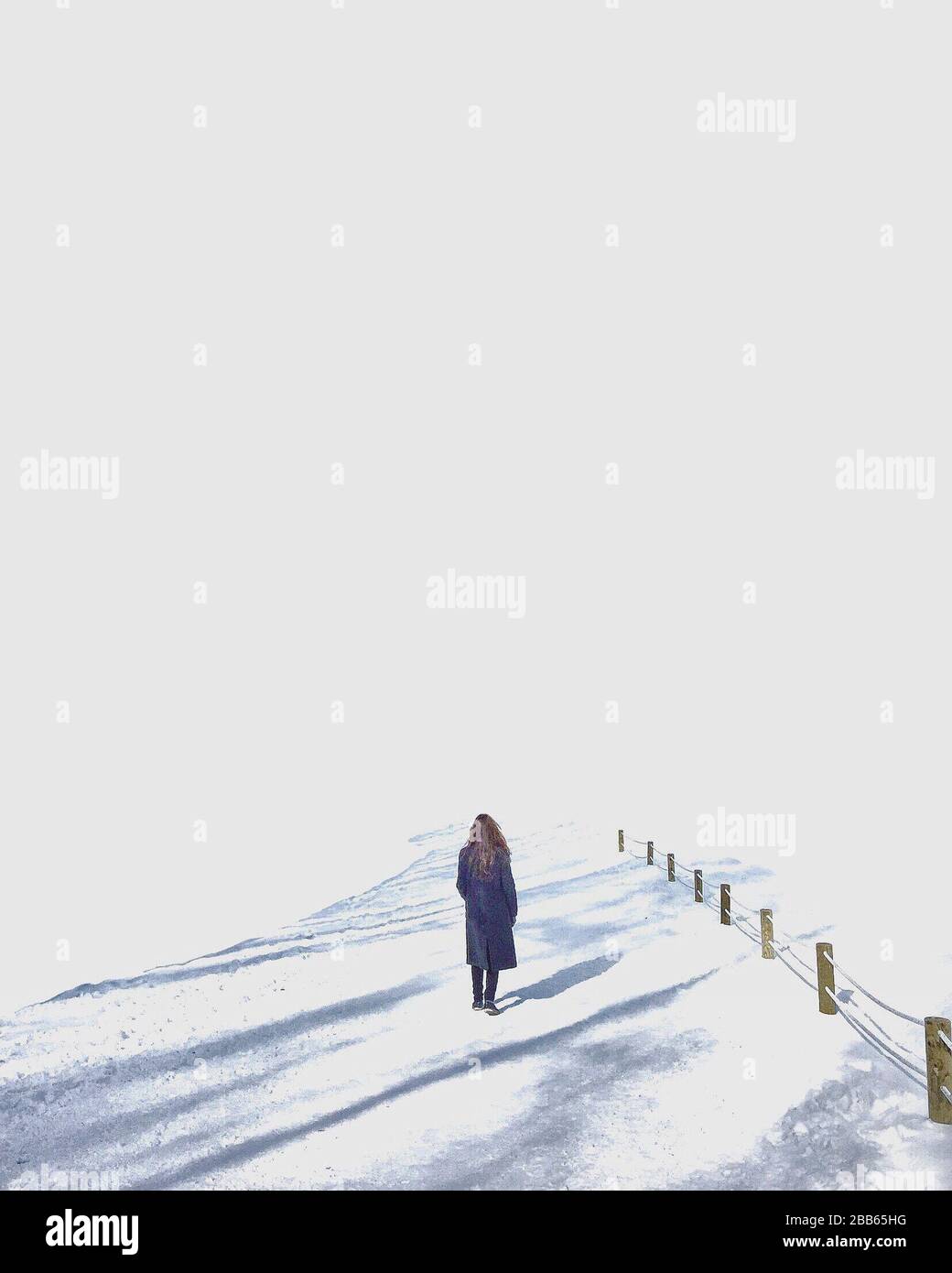 Rückansicht eines Mädchens, das im Schnee im Park spazieren geht, Südkorea Stockfoto