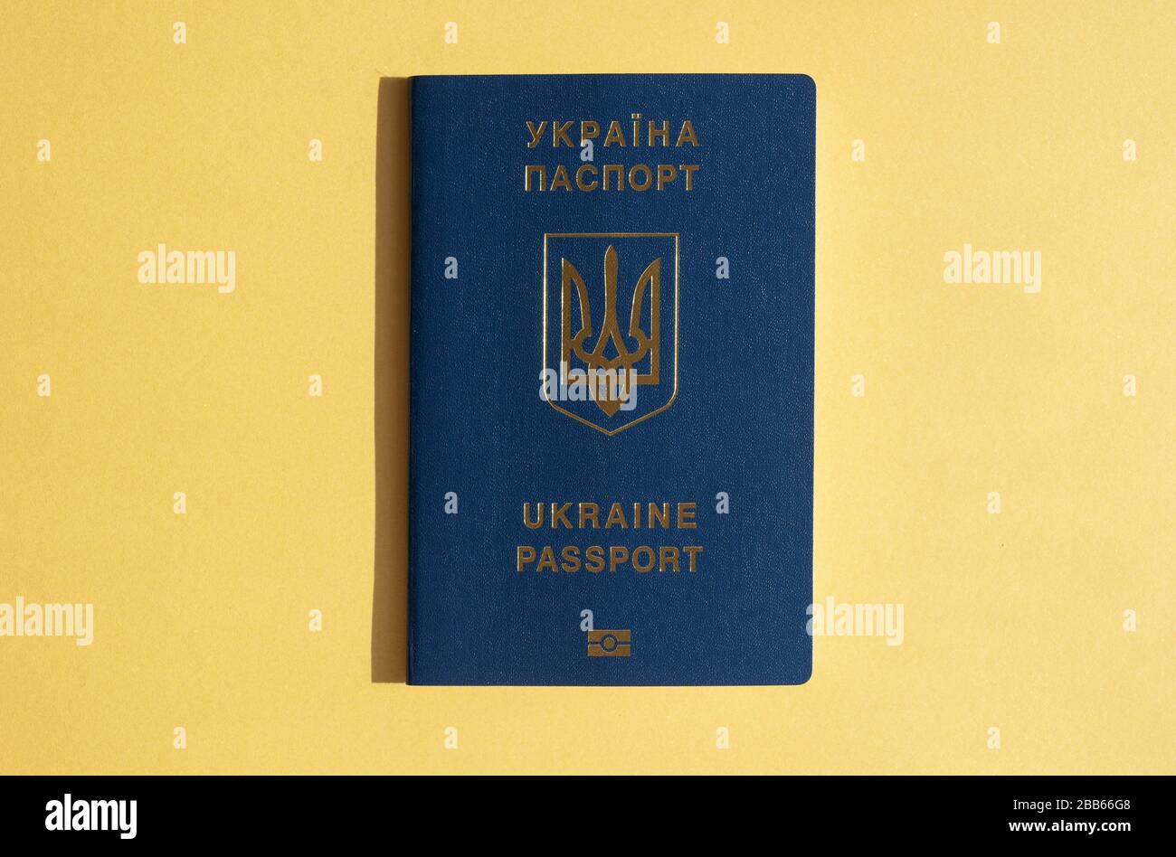 Ausländischer Pass der Ukraine, isoliert auf dem leuchtend gelben sonnigen Hintergrund. Modernes Reisekonzept, ukrainische Reisen Stockfoto