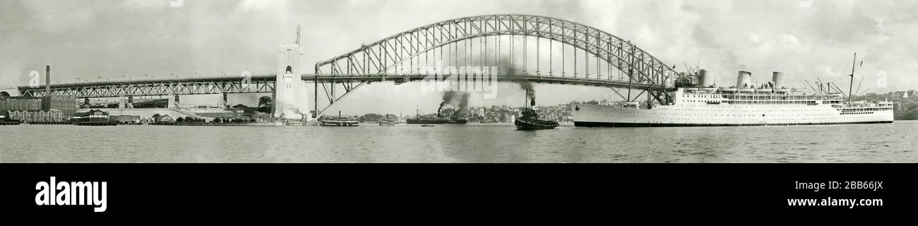 Ein alter Panoramablick auf die Sydney Harbour Bridge aus den 1930er Jahren mit Blick nach Westen im November 1931, als die Brücke kurz vor ihrer Fertigstellung stand. Der P&O-Ozeandampfer 'Strathnaver' auf ihrer Jungfernfahrt von London wird von Schleppbooten darunter geführt. Die Sydney Harbour Bridge ist eine Stahlbogenbrücke. Es wurde von Dorman Long aus Middlesbrough, England entworfen und gebaut. Der letzte Stein des Nordwestpylons (rechts abgebildet) wurde im Januar 1932 aufgestellt. März 1932 eröffnet wurde. Die RMS Strathnaver von P&O war Teil der Schiffe der Royal Mail, die die Strecke zwischen Großbritannien und Brisbane, Queensland, Australien, abarbeiteten. Stockfoto
