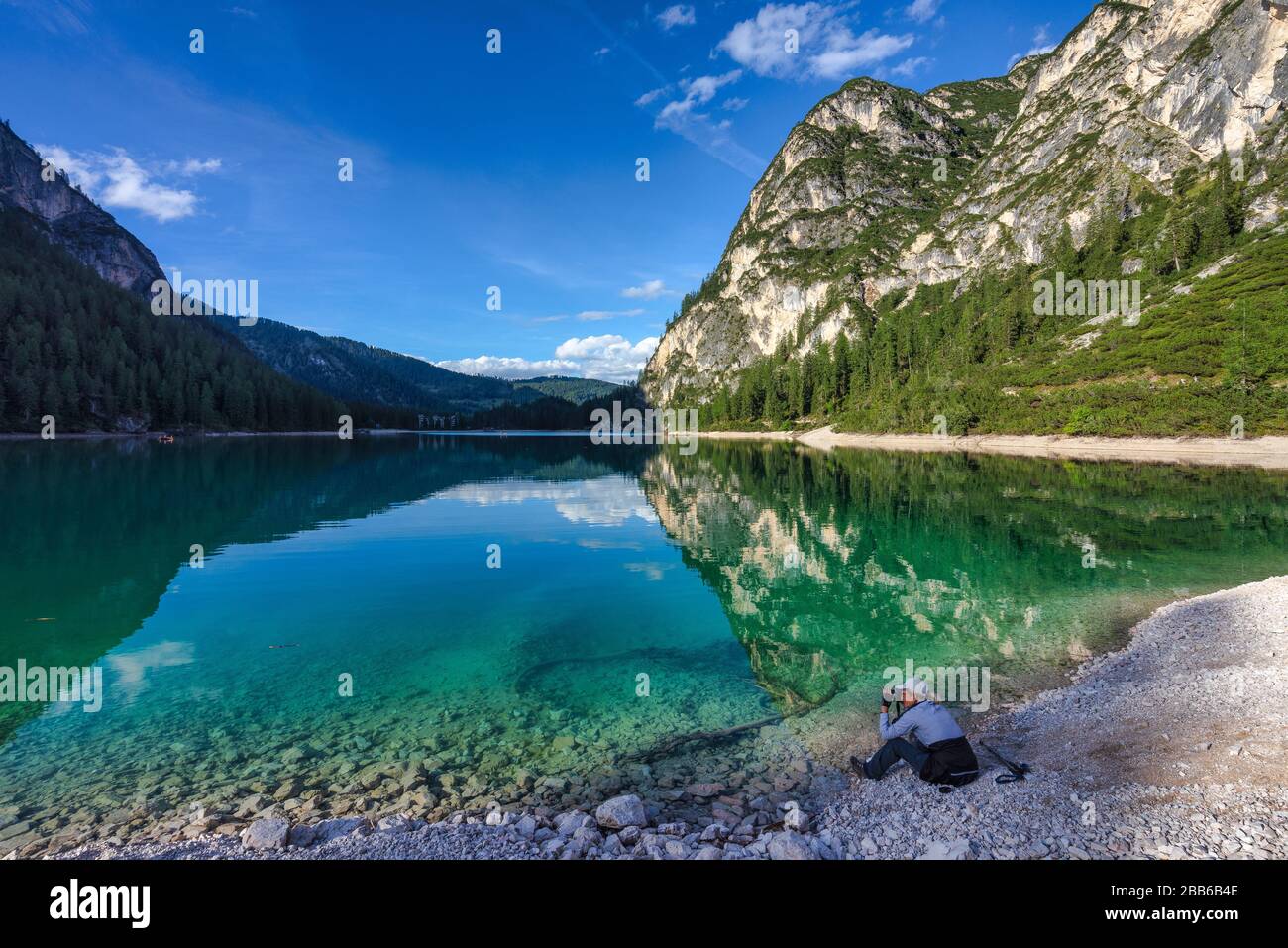 Frau, die am Braiesee sitzt und ein Foto mitnimmt, in Südtirol, Italien Stockfoto