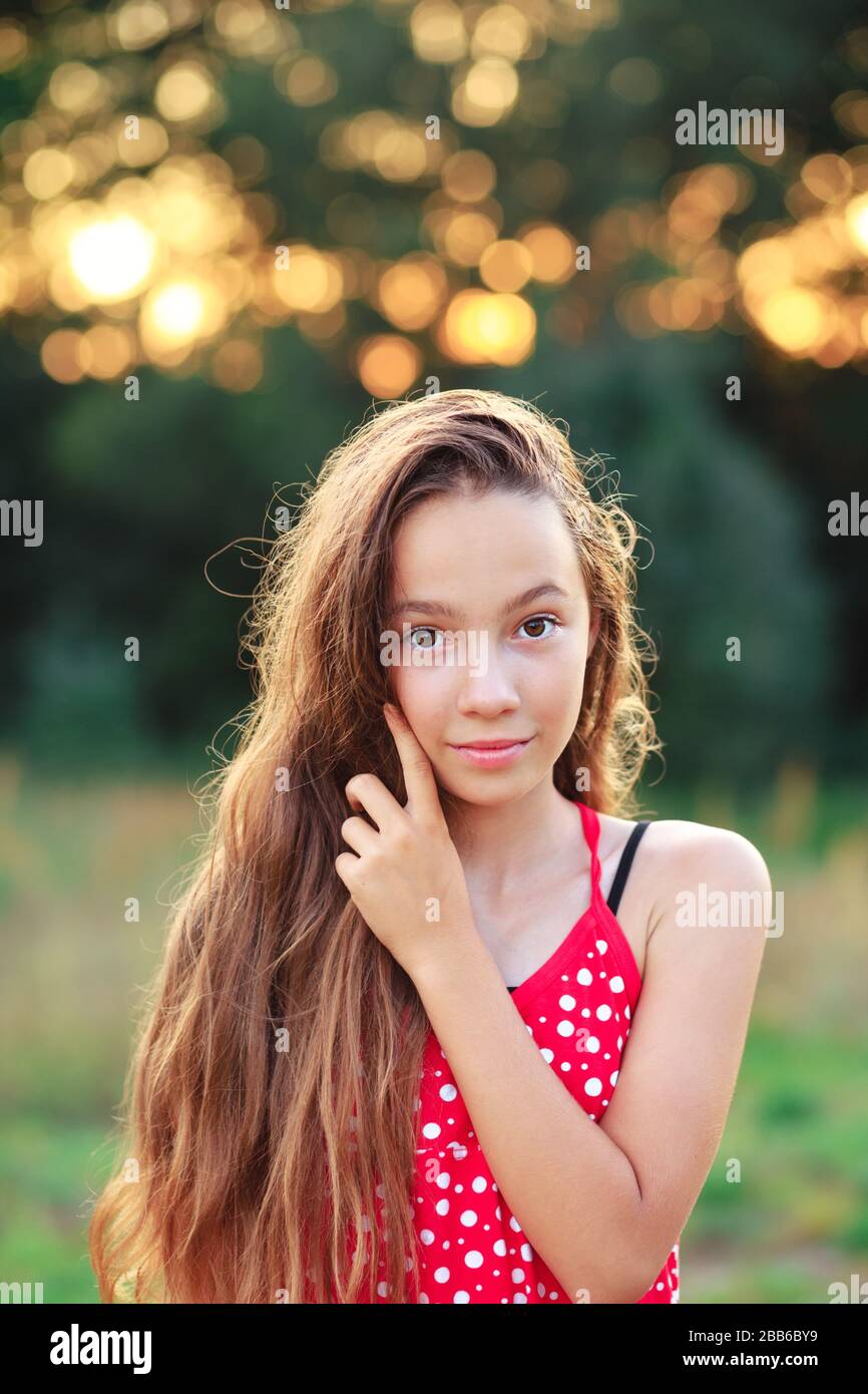 Das schöne Teen Girl lächelt und genießt die Natur im Park bei Sonnenuntergang Stockfoto