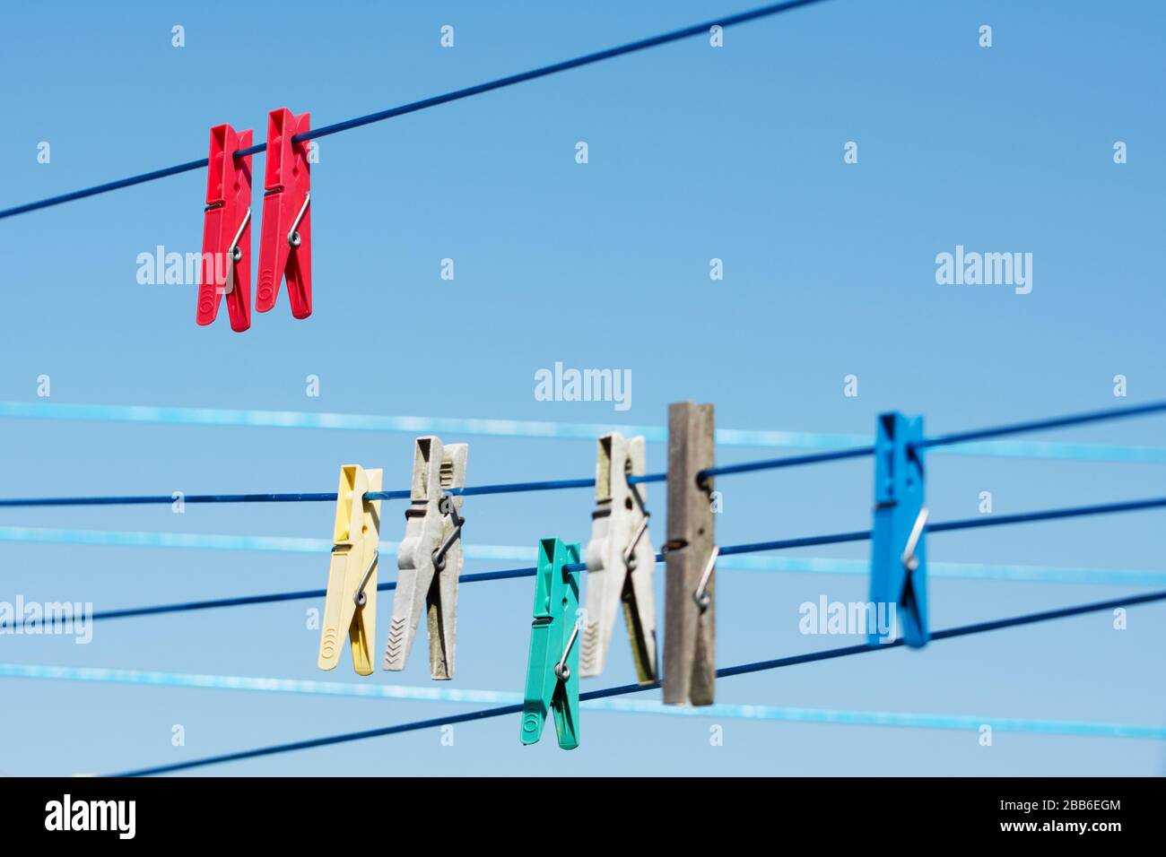 Linien mit bunten Kleidern gegen blauen Himmel Stockfoto
