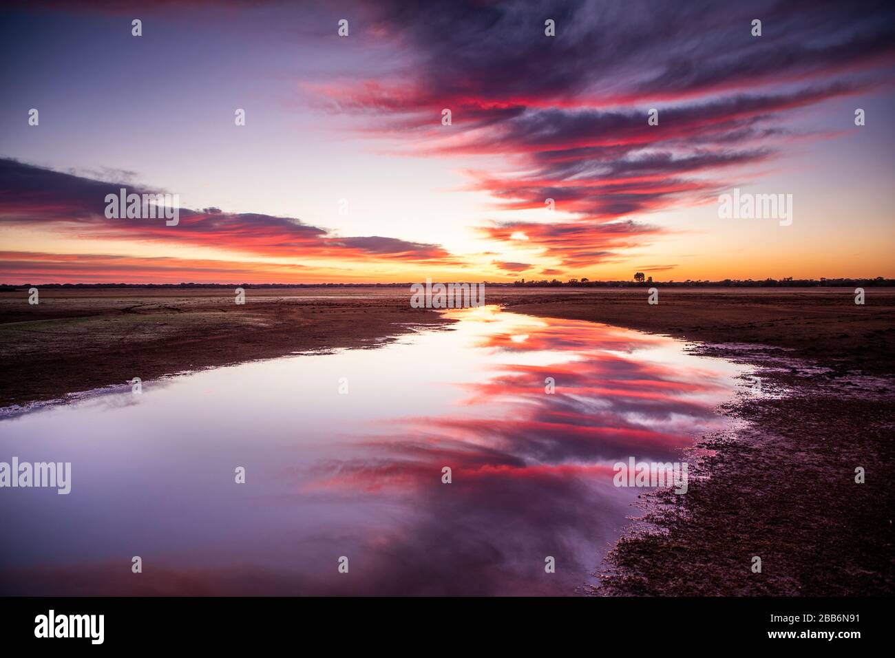 Sonnenuntergangsreflexionen in einem Wasserloch im Outback ...