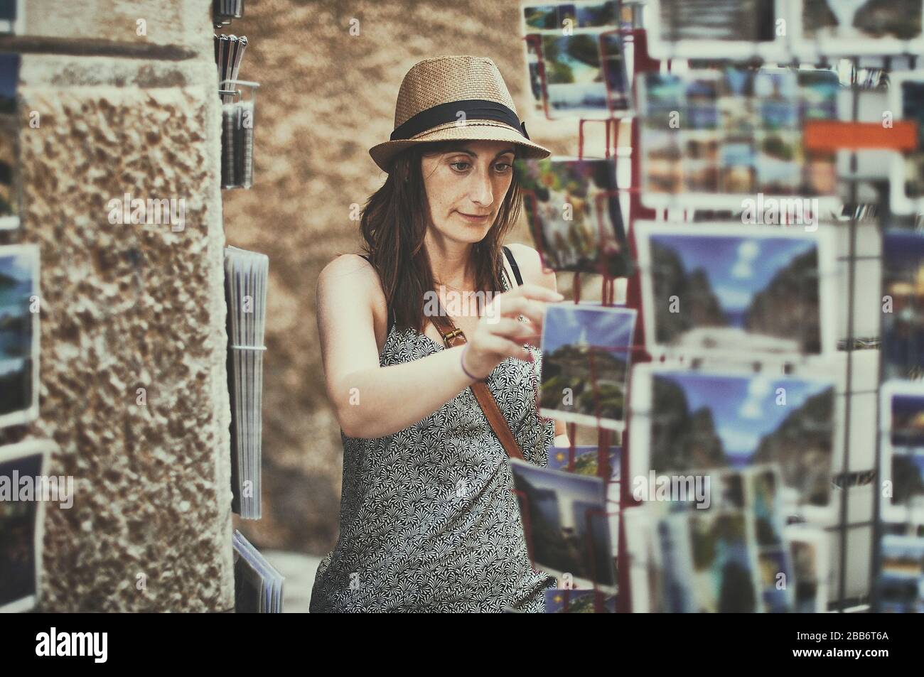 Frau, die eine Postkarte auswählt, Mallorca, Balearen, Spanien Stockfoto