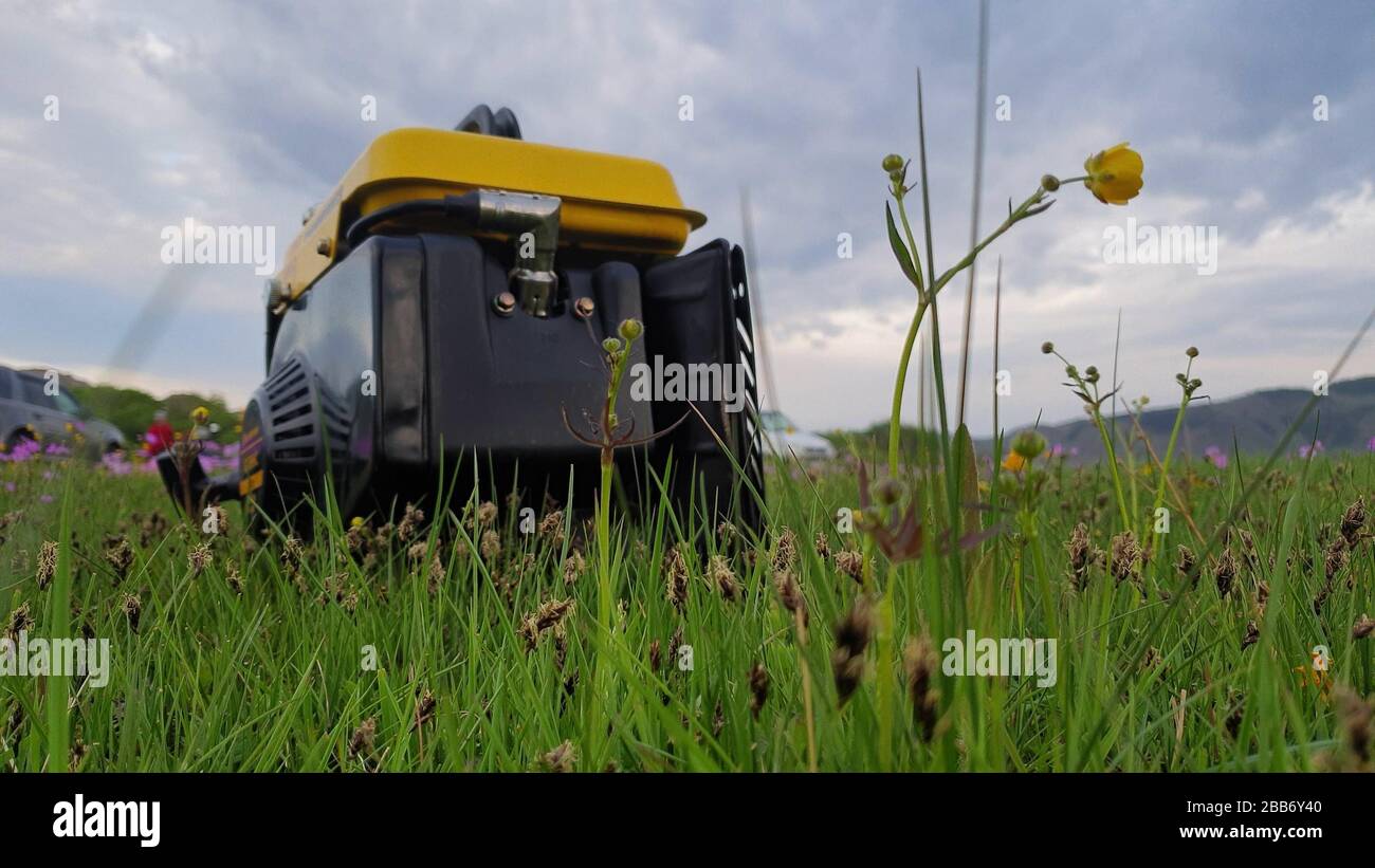 Nahaufnahme des mobilen Stromgenerators für Gasdiesel arbeiten auf Gras. Benzinbetriebene tragbare Generatoren liefern elektrischen Strom. Stockfoto