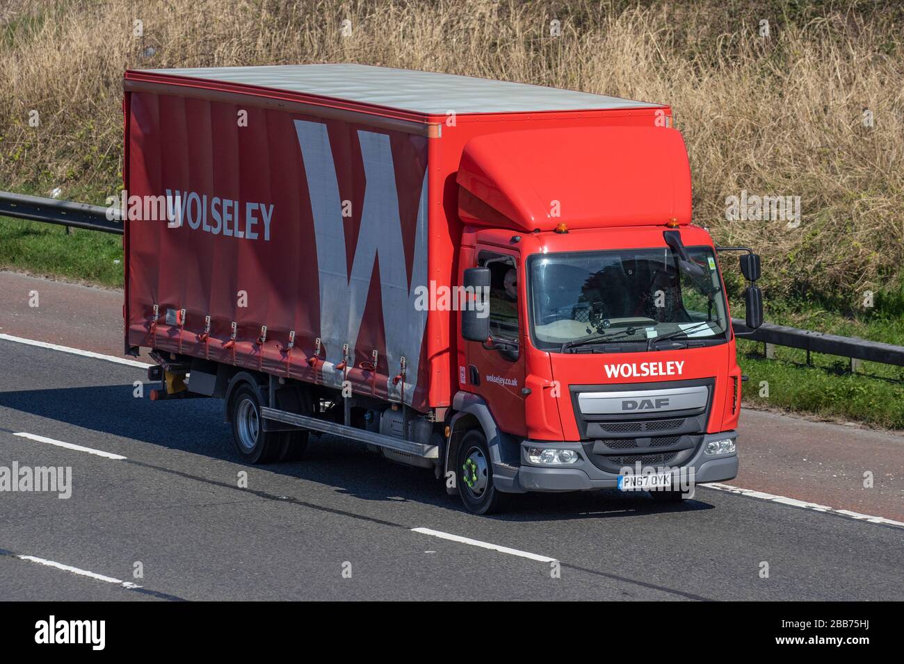Wolseley Plumbing Transport-Lieferwagen, roter Lkw, Transport, LKW, Frachtführer, DAF-Fahrzeug, europäischer kommerzieller Transport, Industrie, M61 in Manchester, Großbritannien Stockfoto