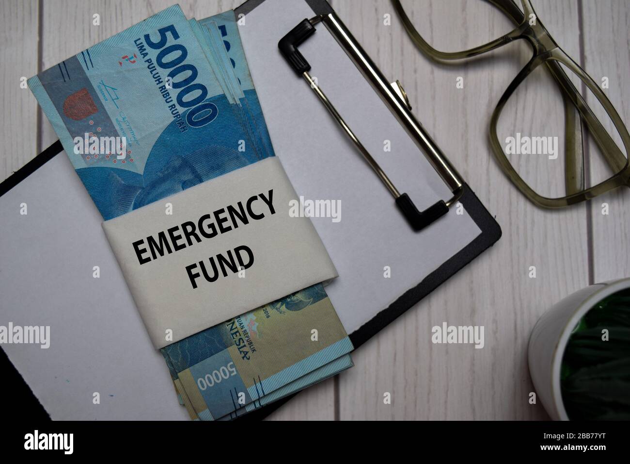 Notfallfondstext und indonesische Rupiah isoliert am Office Desk. Stockfoto