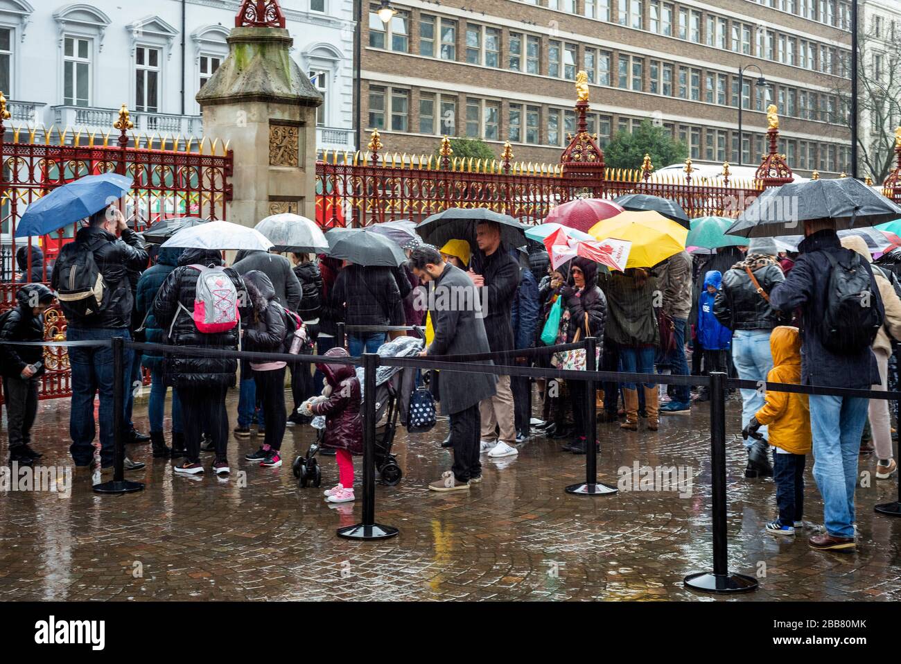 The Natural History Museum London Touristen mit Regenschirmen warten in der Schlange auf den Eintritt an einem Regentag in London, Großbritannien Stockfoto