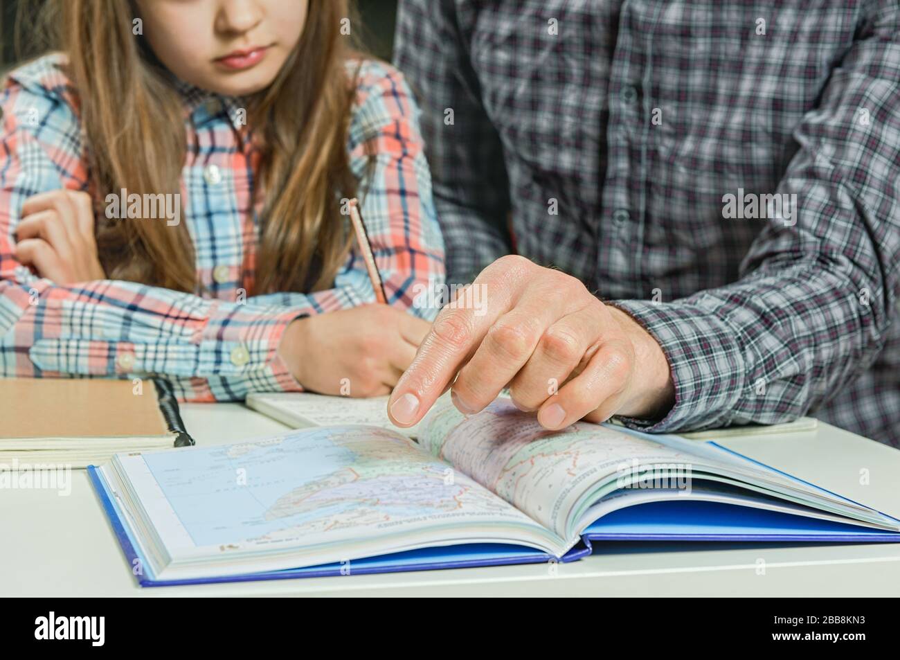 Homeschooling. Vater hilft Tochter bei ihren Hausaufgaben. Lernkonzept. Kommunikationskonzept. Stockfoto