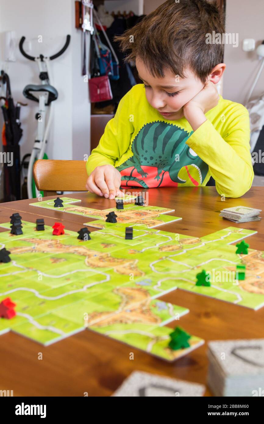 Kinderkind spielt Carcassone in Quarantäne zu Hause Stockfoto