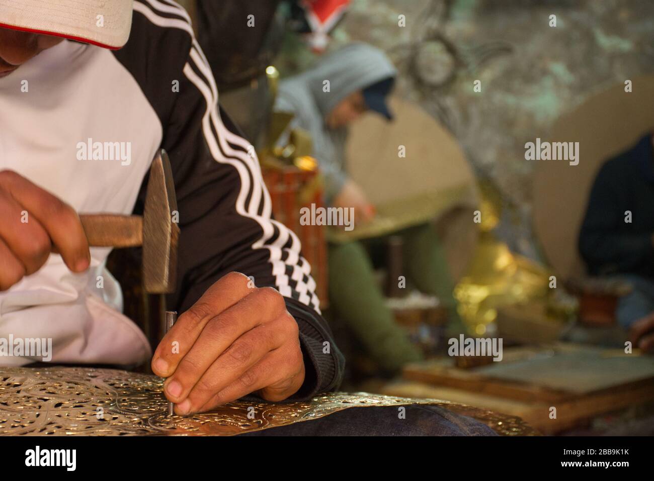 Metallarbeiter basteln in ihrer winzigen Werkstatt im Herzen der Medina in Marrakesch, Marokko. Stockfoto