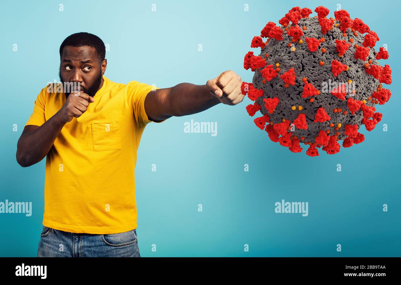 Der Mensch greift mit einem Schlag das Coronavirus an. Blauer Hintergrund Stockfoto