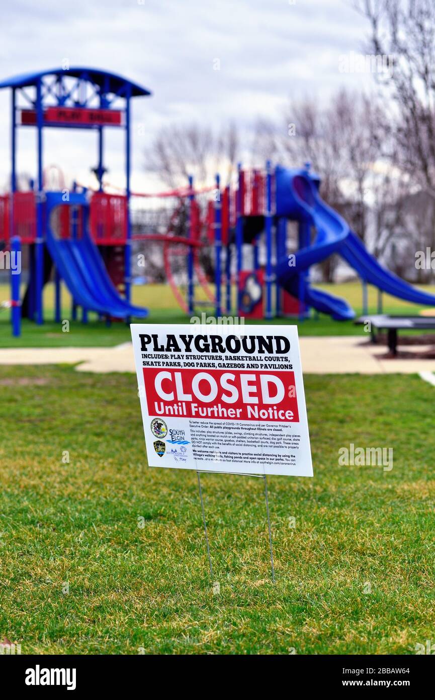 South Elgin, Illinois, USA. Eine leerstehende Gruppe von Spielgeräten, die sich in einem öffentlichen Park befinden, sitzt hinter einem Schild, das die Ausrüstung für geschlossen erklärt. Stockfoto