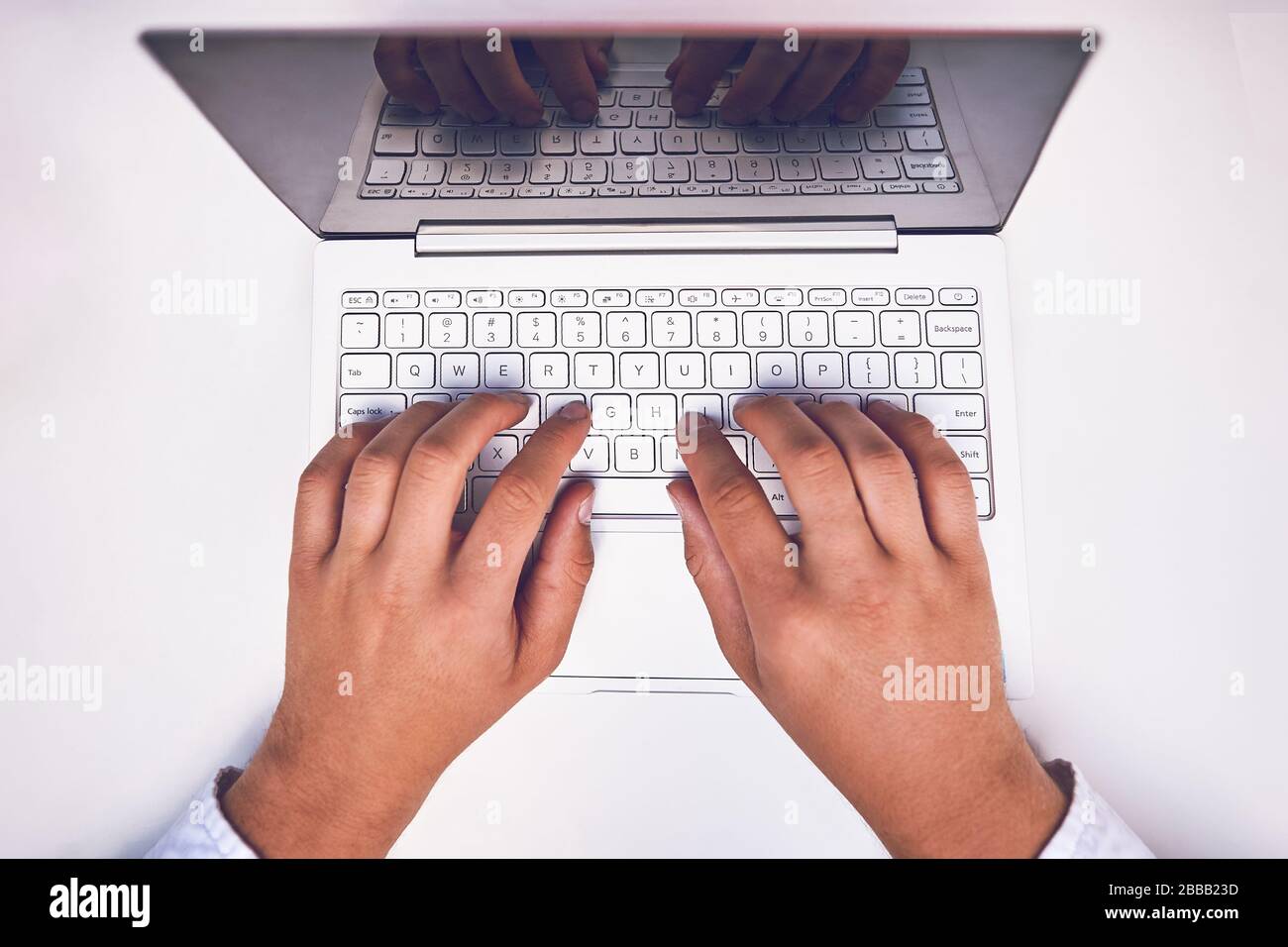 Hand auf Laptop Tastatur mit leerer Bildschirm Monitor Stockfoto