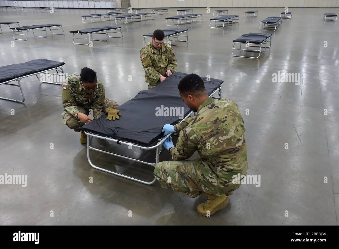 Soldaten mit der Nationalgarde der Maryland Army stellen im Rahmen der Einrichtung einer Bundesärztestation im Baltimore Convention Center in Baltimore, Maryland, Samstag, 28. März 2020 ein Kinderbett zusammen. Die Station wurde als alternatives medizinisches Zentrum konzipiert, um mögliche Überbelegung in den Krankenhäusern der Region infolge des COVID-19-Ausbruchs zu lindern. Etwa 100 Soldaten unterstützten die Einrichtung von 250 Betten und damit verbundener Ausrüstung im Kongresszentrum, während landesweit fast 14.000 Mitglieder der Nationalgarde für die Lieferung von Vorräten, den Betrieb mobiler Testzentren und die Arbeit sorgen Stockfoto