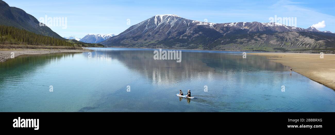 Zwei junge Frauen paddeln auf einem Kajakhybrid über Bennett Lake in Carcross, Yukon Territory, Kanada Stockfoto
