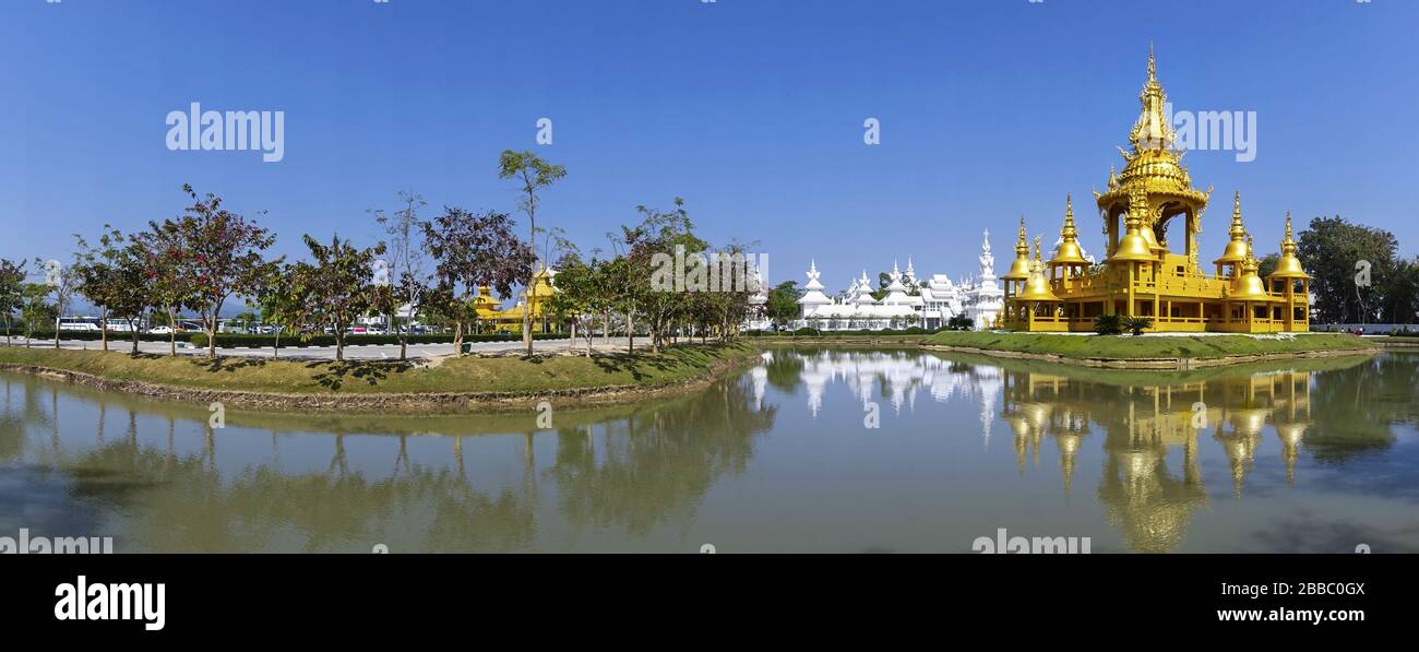 Der Goldene Tempel spiegelt sich in der ruhigen Panoramalandschaft des Teichs im berühmten buddhistischen Wat Rong Khun, Provinz Chiang Rai, Thailand, wider Stockfoto