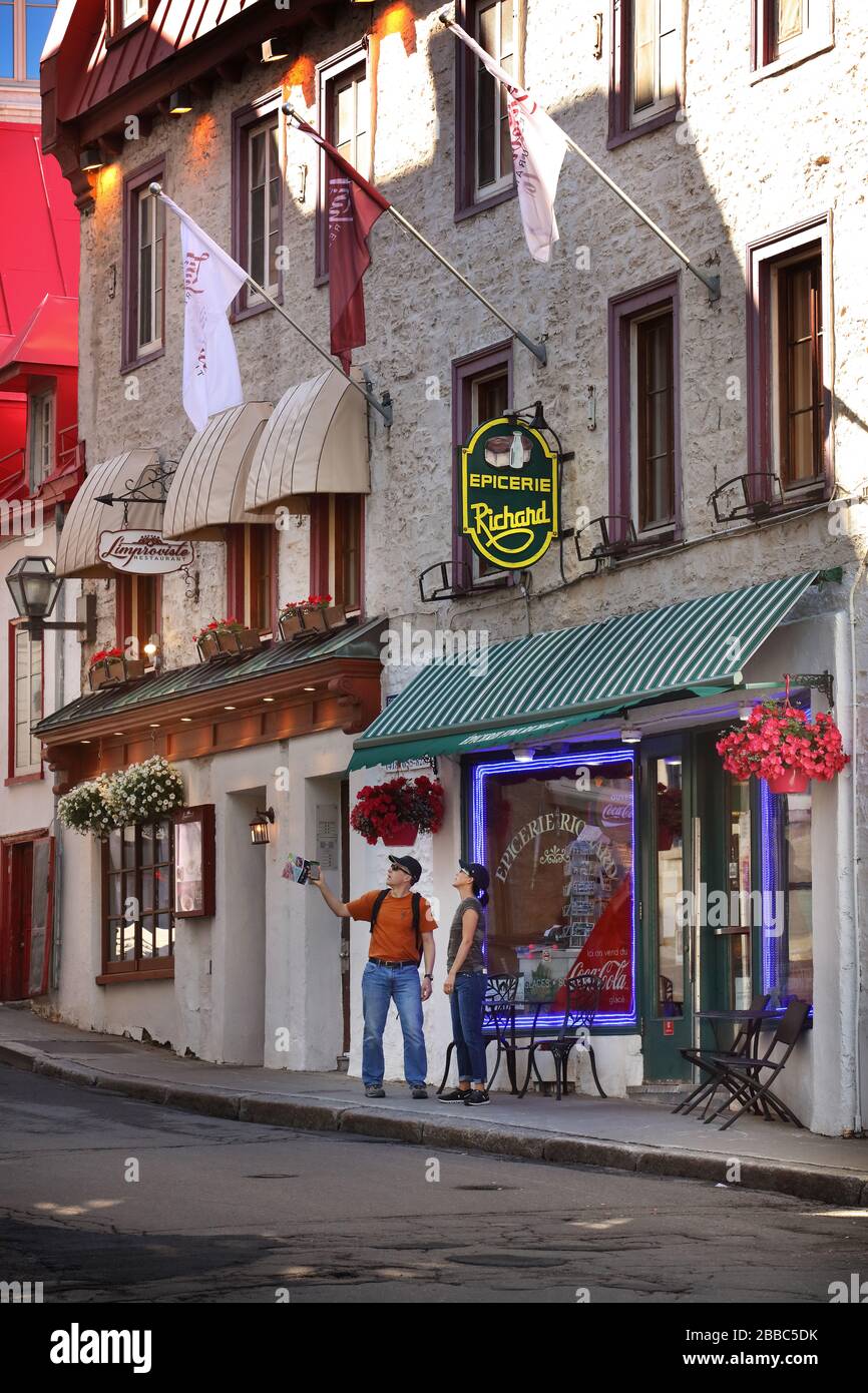 Ein Paar vor einem kleinen, unabhängigen Lebensmittelgeschäft in der Rue des Jardins in der historischen Oberstadt der Altstadt von Quebec, Provinz Quebec, Kanada Stockfoto