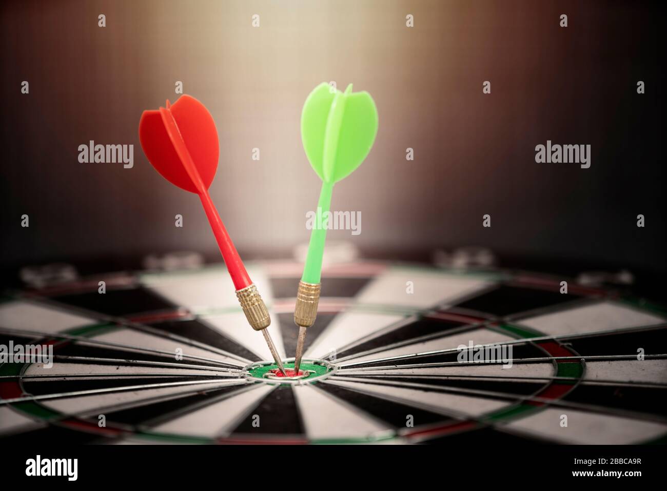 Nahaufnahme roten und grünen Pfeil treffen auf Ziel Zentrum der Dartscheibe, Geschäftskonzept Stockfoto