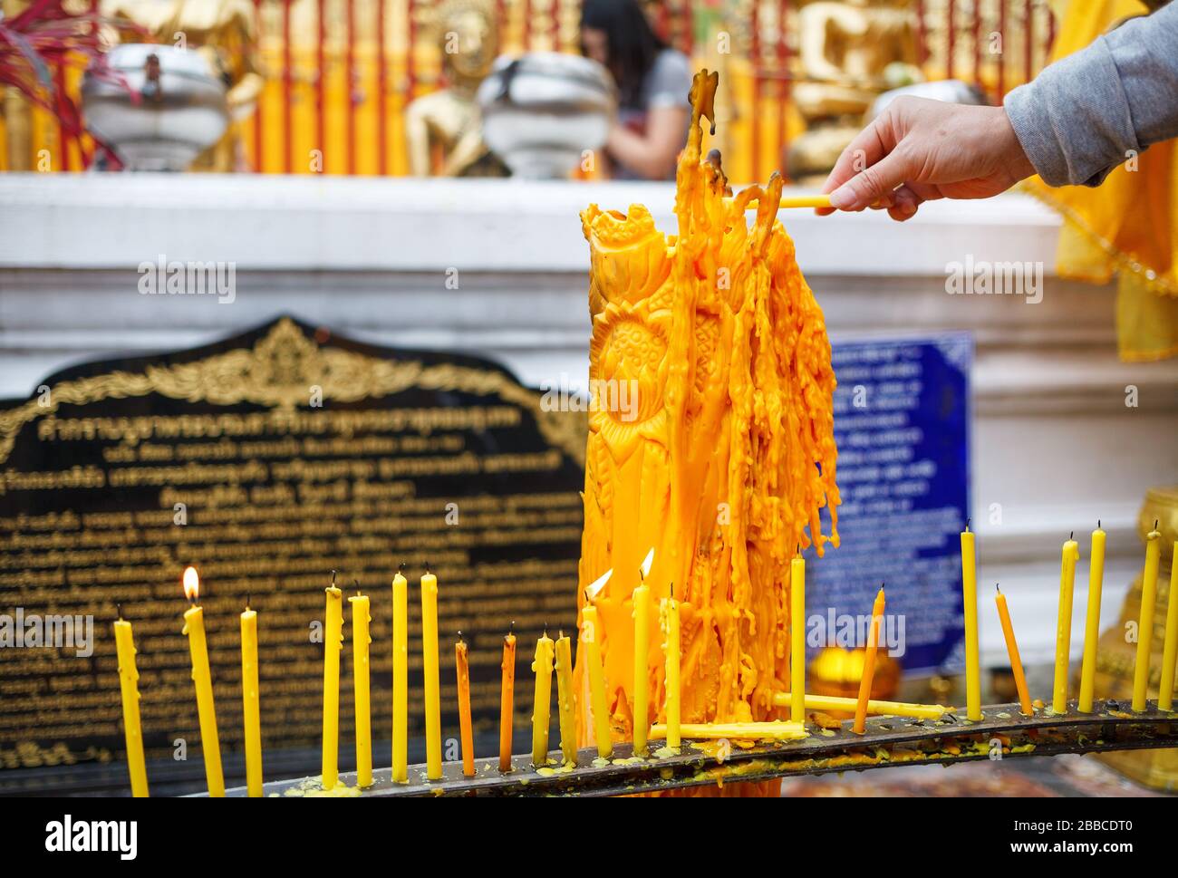 Hand mit Kerze im buddhistischen Tempel Wat Doi Suthep in Ciang Mai, Thailand Stockfoto