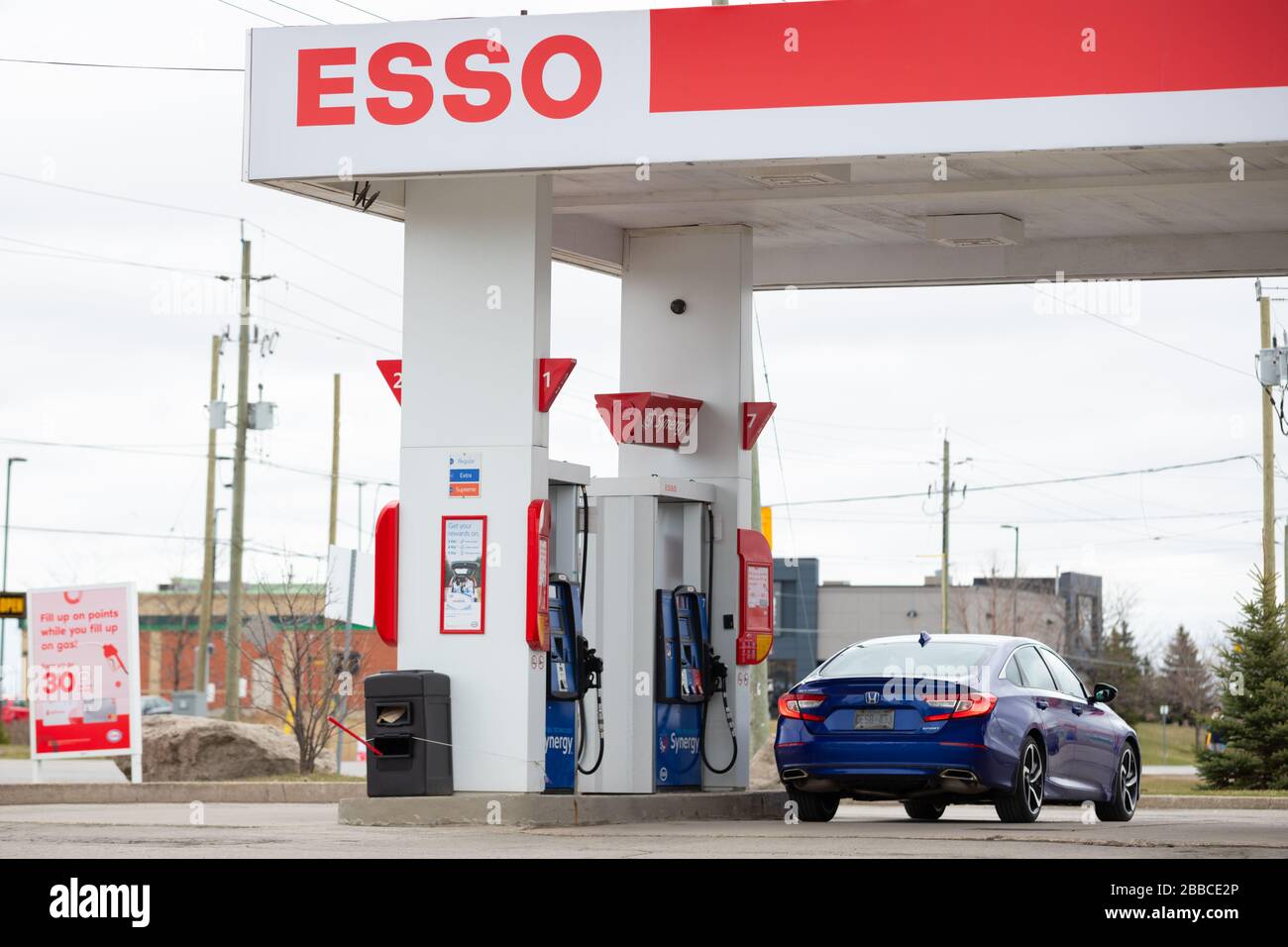 Ansicht, die einen Abschnitt einer Esso-Tankstelle mit einem an der Kraftstoffpumpe geparkten Fahrzeug anzeigt Stockfoto