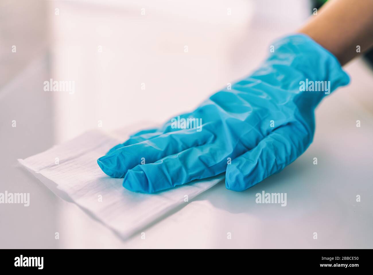 Oberflächendesinfektionierung Hausreinigung mit desinfizierenden antibakteriellen Wischtüchern Schutz gegen COVID-19-Vermehrung mit medizinischen blauen Handschuhen. Desinfizieren Sie Oberflächen in Krankenhäusern und öffentlichen Bereichen. Stockfoto