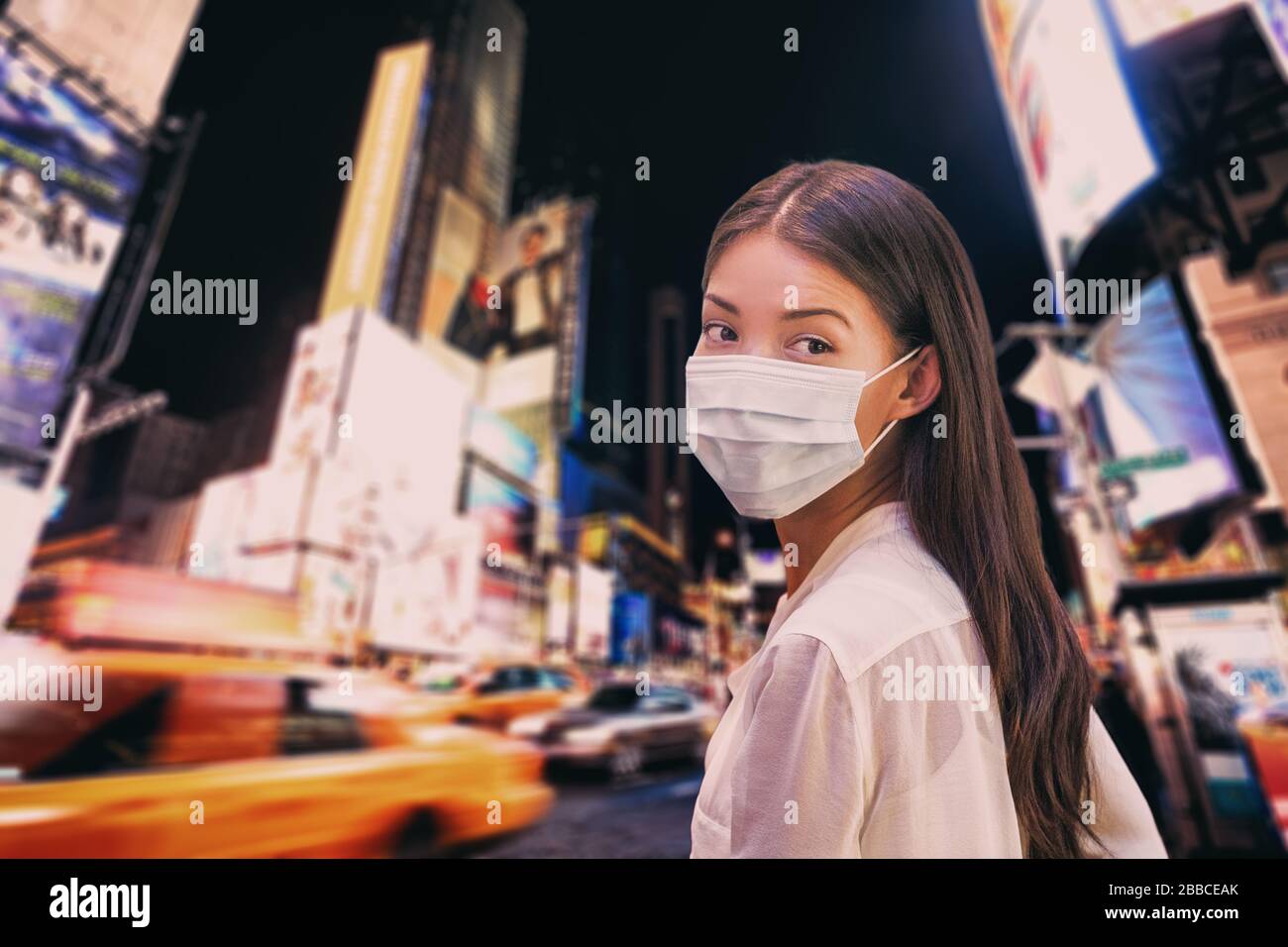 Fälle von New York City COVID-19 Coronavirus. NYC Quarantäne Reise-Verbot asiatische Frauen tragen Gesichtsmaske gehen nachts auf dem Times Square. Corona-Virus. Stockfoto