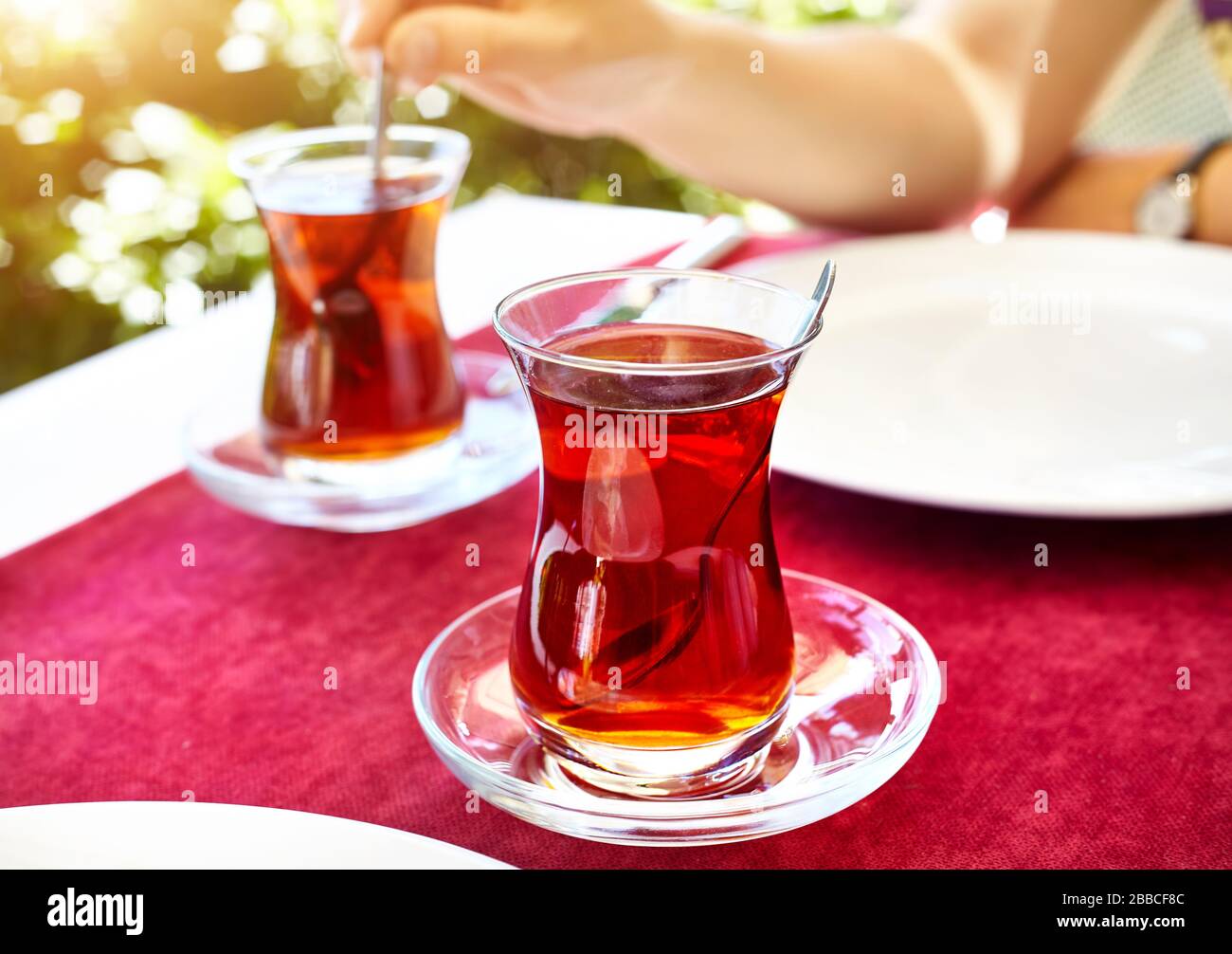 Türkischer Tee im traditionellen Glas im Restaurant auf dem roten Tisch in der Türkei Stockfoto