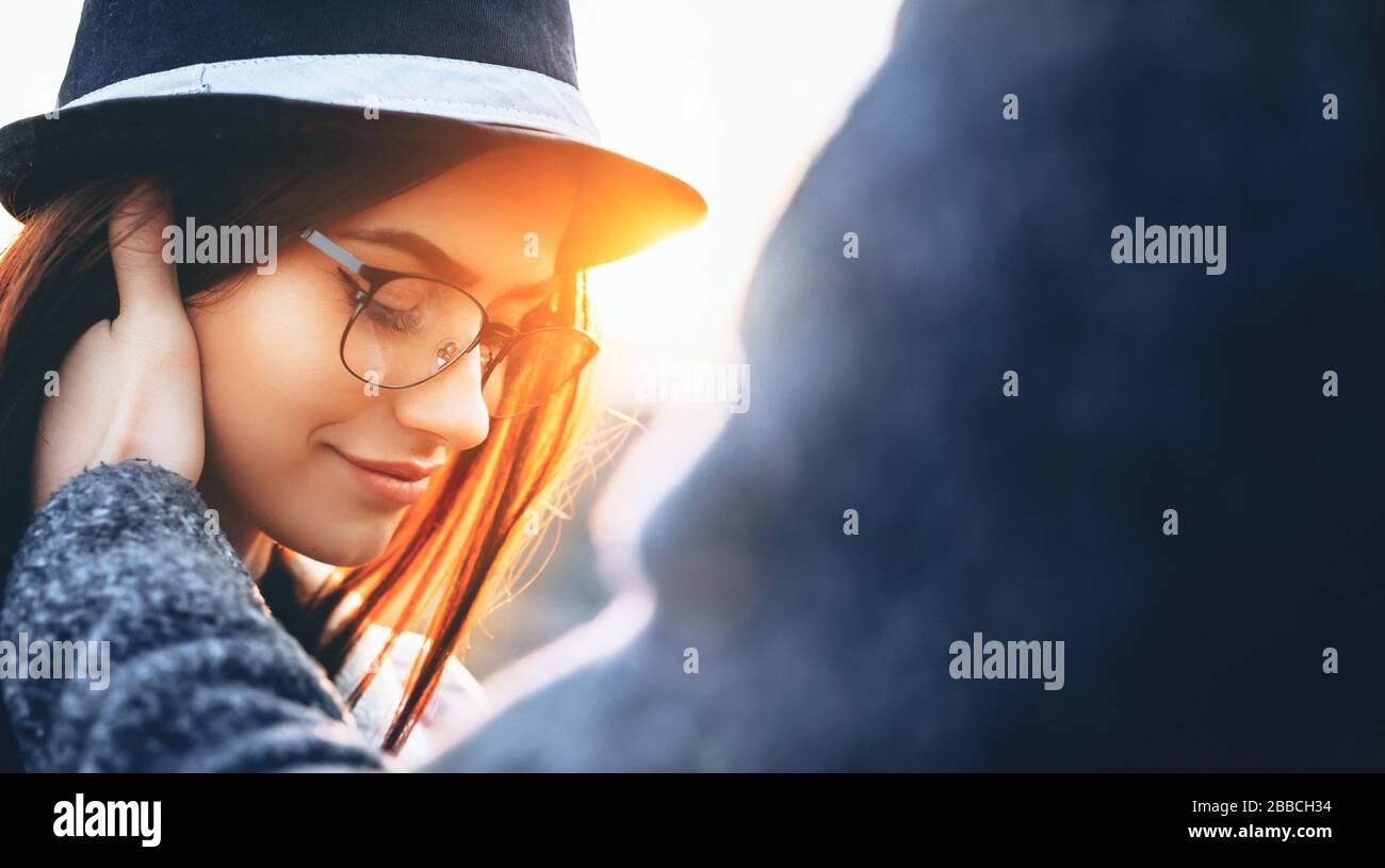 Schöne Frauen mit Hut und Brille, die hinunterschauen, werden von ihrem Liebhaber berührt, der an einem sonnigen Abend posiert Stockfoto Schöne Frauen mit Hut und Brille, die hinunterschauen, werden von ihrem Liebhaber berührt, der an einem sonnigen Abend posiert Stockfoto