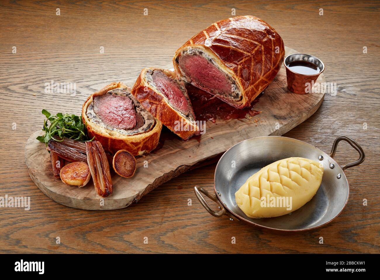 Beef wellington in Scheiben geschnitten serviert Brett teilen Platte Holz Frisch gekochtes, rosafarbenes, perfektes Gebäckfleisch Stockfoto