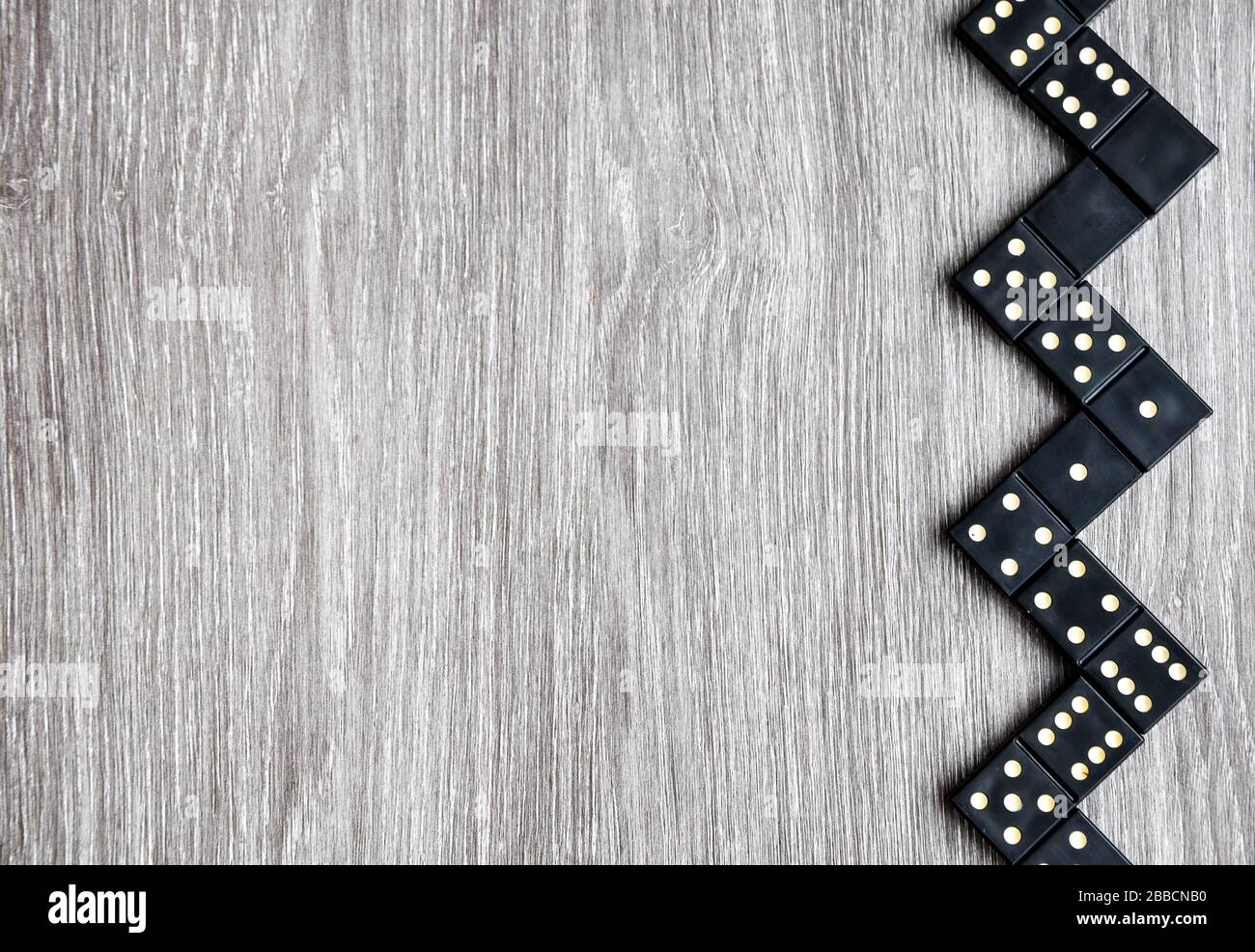 Draufsicht auf schwarze Domino-Würfel auf einem hellen Holztisch,  Spielvorgang von Dominosteinen, Kopierraum Stockfotografie - Alamy