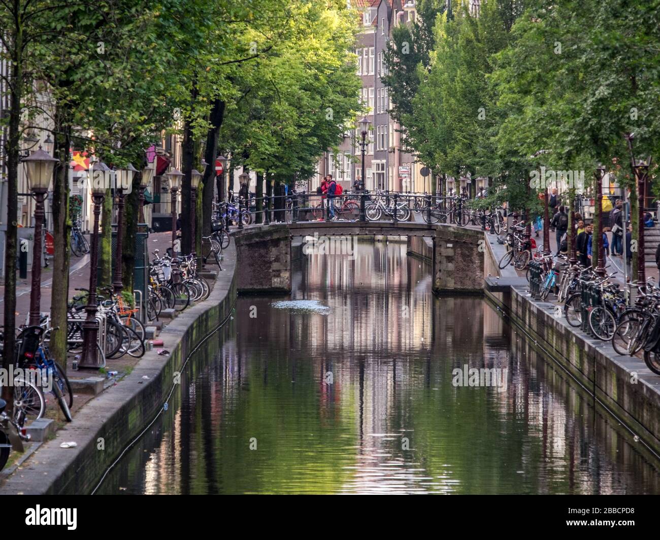 Reflexionen in einem Kanal umgeben von Fahrrädern in Amsterdam, Niederlande Stockfoto