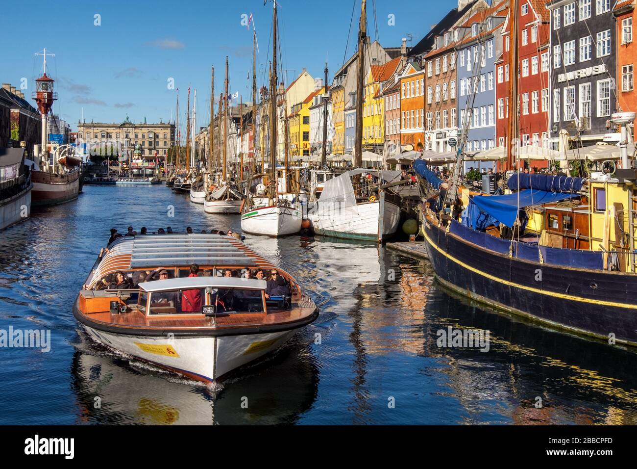 Ausflugsboot auf dem Nyhavn-Kanal und der Promenade mit seinen bunten Fassaden, Hafengebiet aus dem 17. Jahrhundert, Kopenhagen, Dänemark Stockfoto