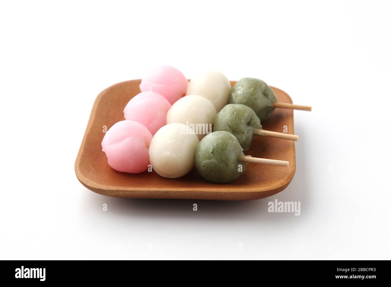 dango 3 farbige kuchenfarbene japanische Süßwaren auf Platte isoliert auf weißem Hintergrund Stockfoto