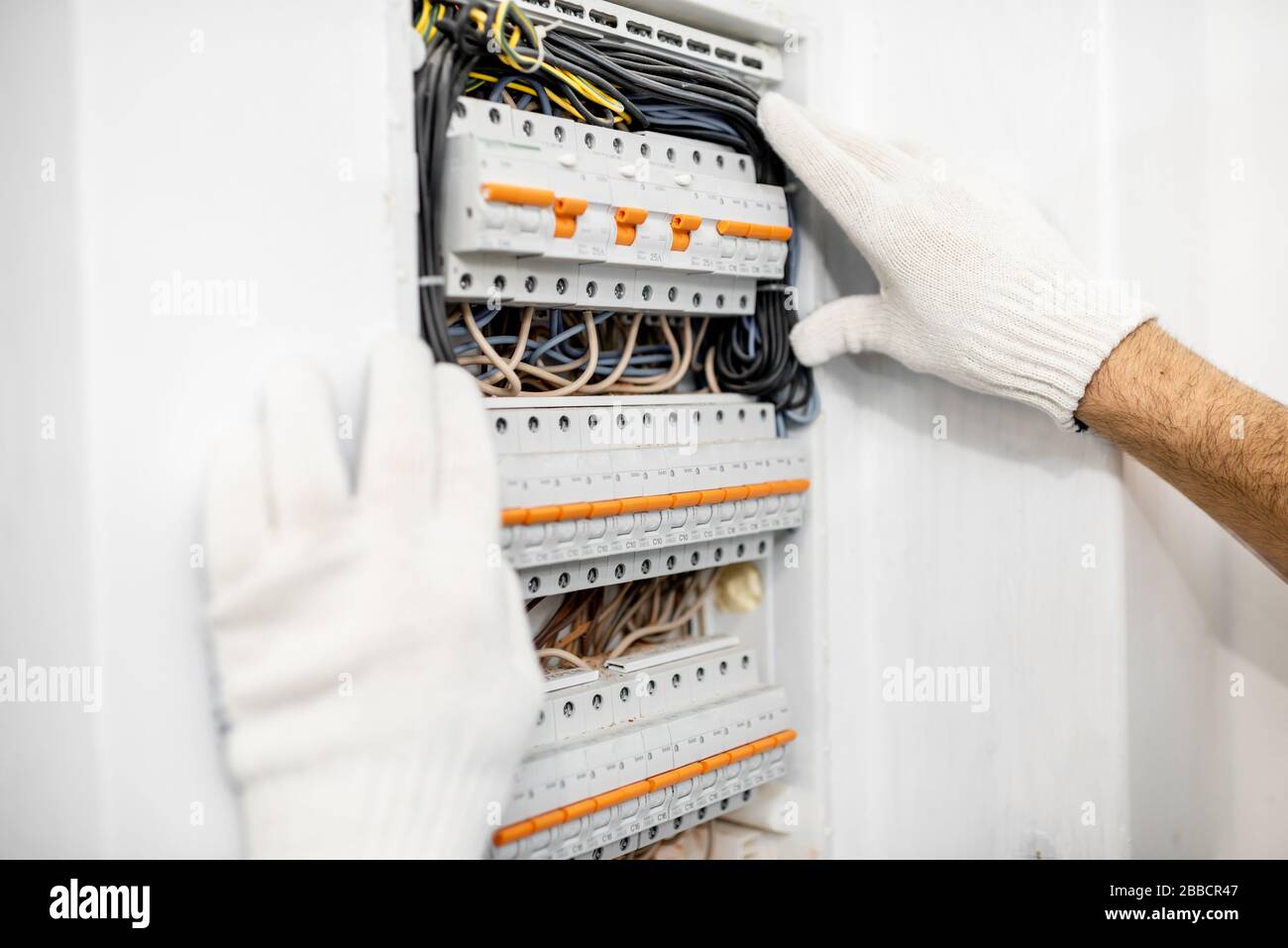 Elektriker installiert oder repariert die elektrische Zentrale des Apartments, Nahansicht Stockfoto