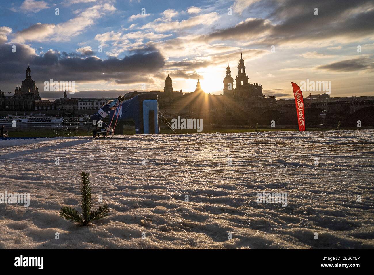 Eine Frau, die beim Paralympischen Skiweltcup am Elbufer, der Skyline der Stadt im Weitblick, Rennen wird Stockfoto