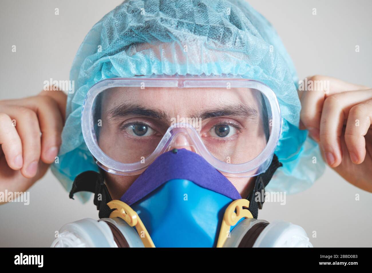 Männliche Person zieht Schutzbrille, Nahansicht an. Medizinisches Personal, Krankenhausmitarbeiter oder Wissenschaftler bei einer Kovid-19-Pandemie. Konzept des persönlichen Gesichtsausdruck Stockfoto