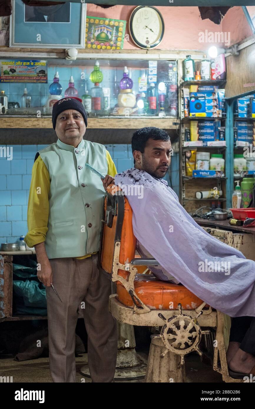 Ein Barbier, der während einer Nassrasur in einem traditionellen indischen Barbier-Shop in Indien für ein Foto posiert. Stockfoto