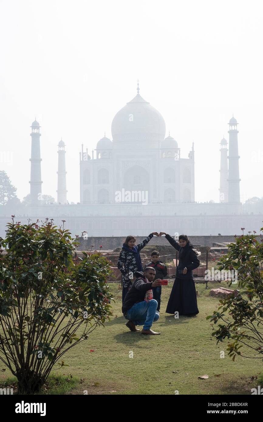 Eine indische Familie auf einem Tag posiert für ein Familienfoto mit Taj Mahal im Hintergrund Stockfoto