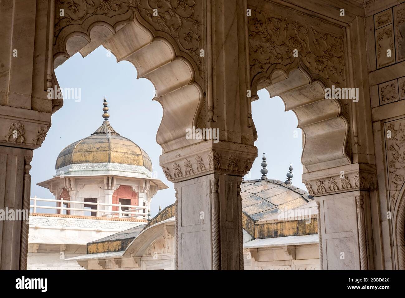 Blick auf einen Turm durch einen aufwendigen Torbogen im Agra Fort in Indien Stockfoto