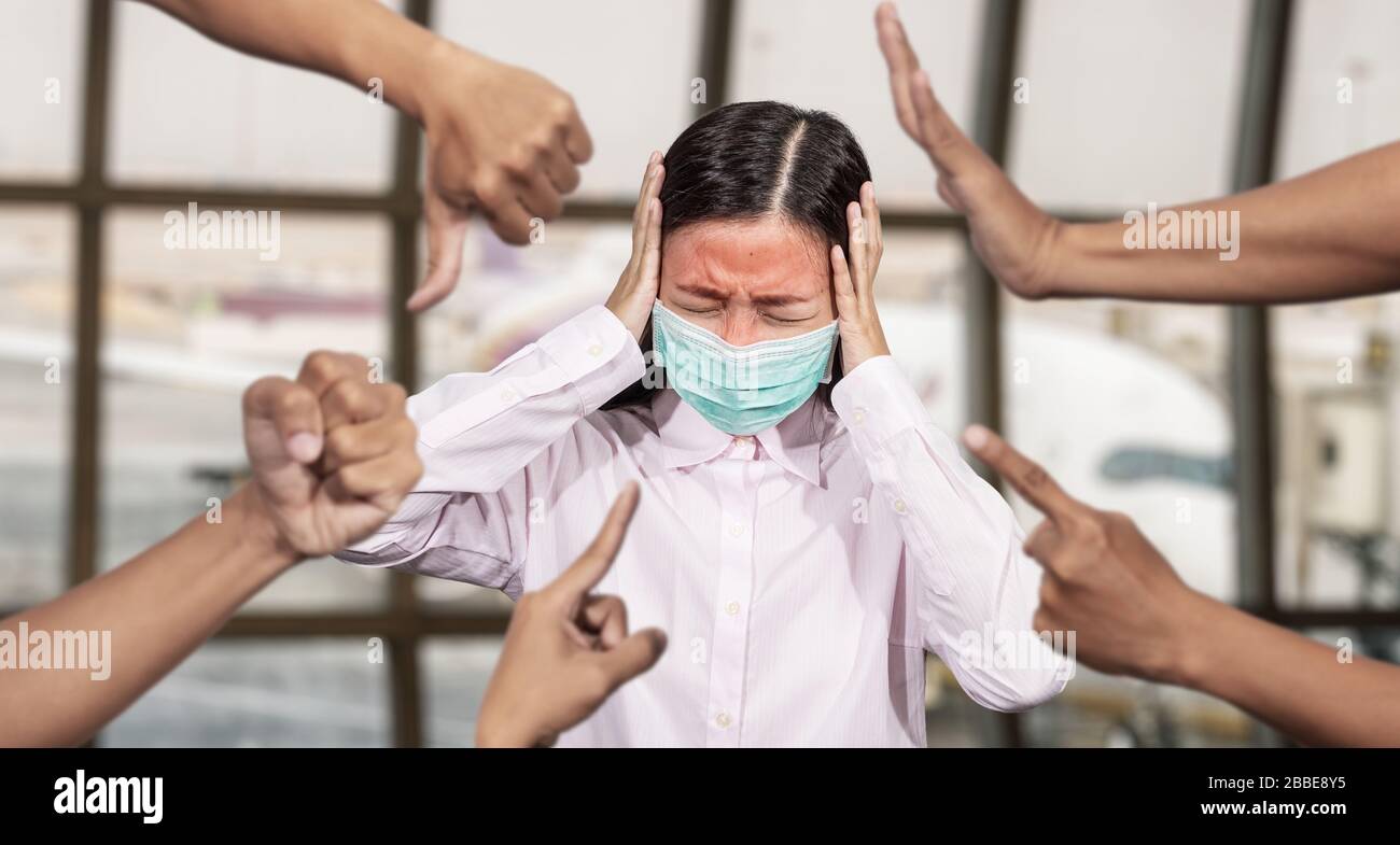 Asian Woman war krank mit hohem Fieber tragen hygienische Maske werden drangsaliert und Hass umgeben von Händen, die sie spotten, in der Ausbruchssituation von Stockfoto