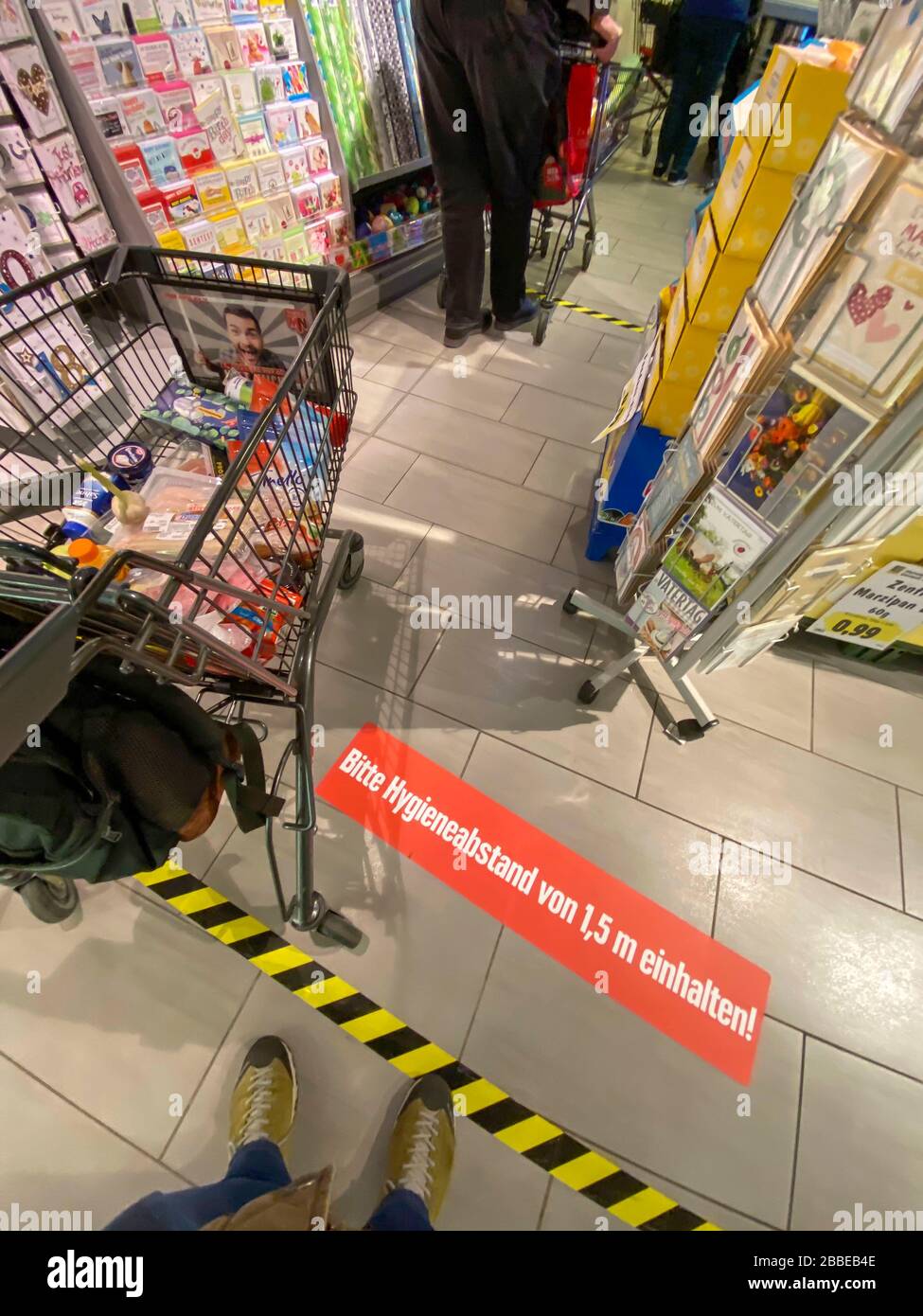 Auswirkungen der Coronakrise in Deutschland, Aufkleber auf dem Boden informiert die Kunden eines Supermarktes über Mindestabstand, Hygieneabstand, 1,5 Stockfoto