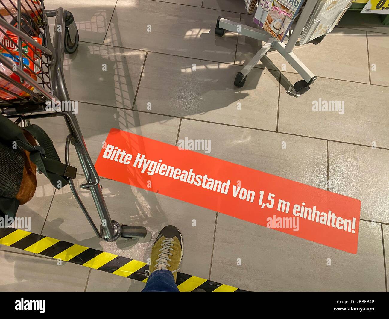 Auswirkungen der Coronakrise in Deutschland, Aufkleber auf dem Boden informiert die Kunden eines Supermarktes über Mindestabstand, Hygieneabstand, 1,5 Stockfoto