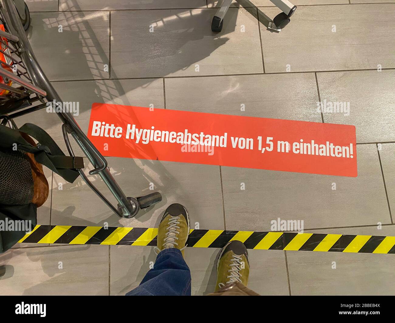 Auswirkungen der Coronakrise in Deutschland, Aufkleber auf dem Boden informiert die Kunden eines Supermarktes über Mindestabstand, Hygieneabstand, 1,5 Stockfoto
