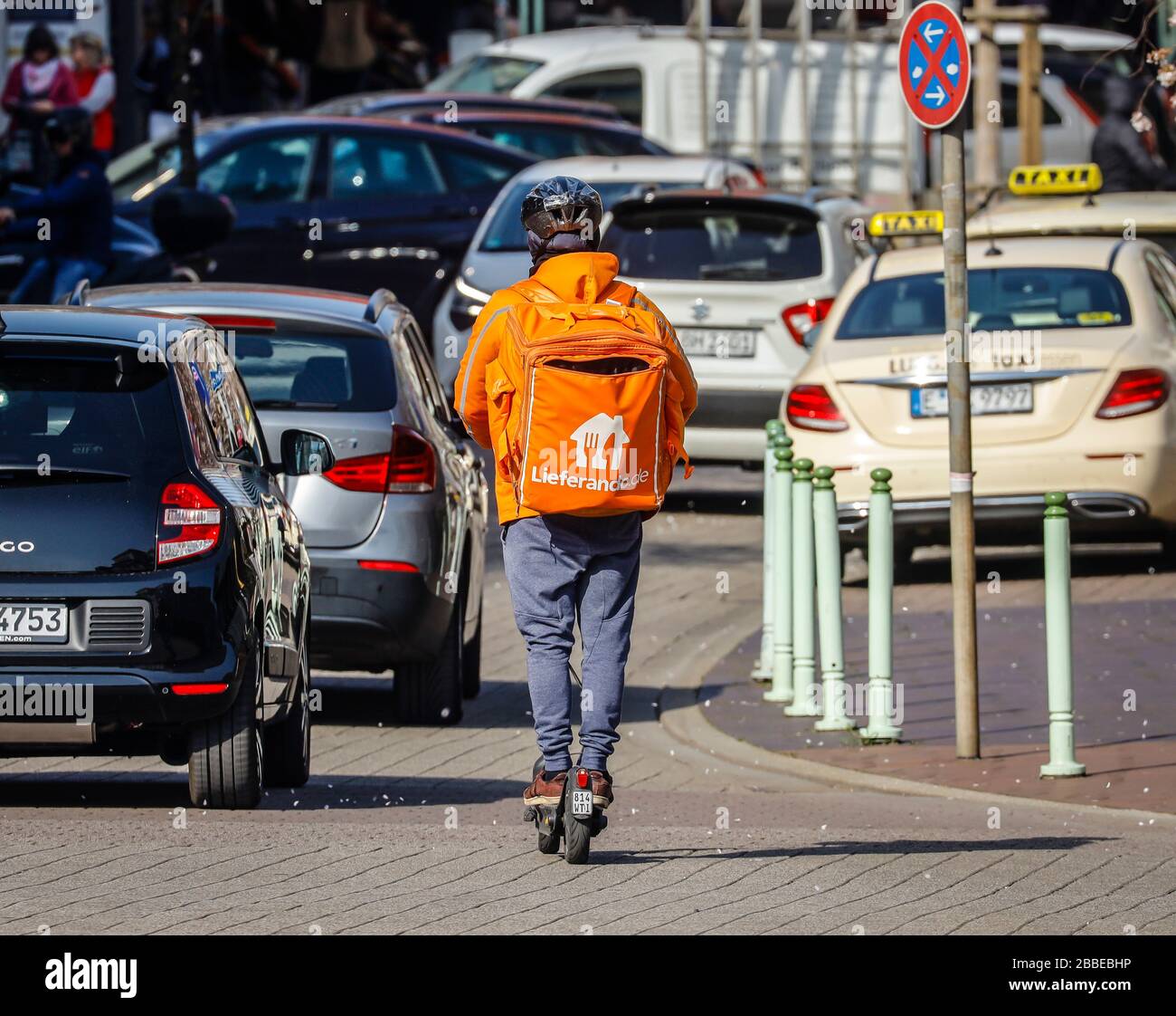 Essen, Ruhrgebiet, Nordrhein-Westfalen, Deutschland - Lieferservice Lieferando, ein Kurierfahrer auf der Straße mit einem Elektroscooter liefert ordre Stockfoto