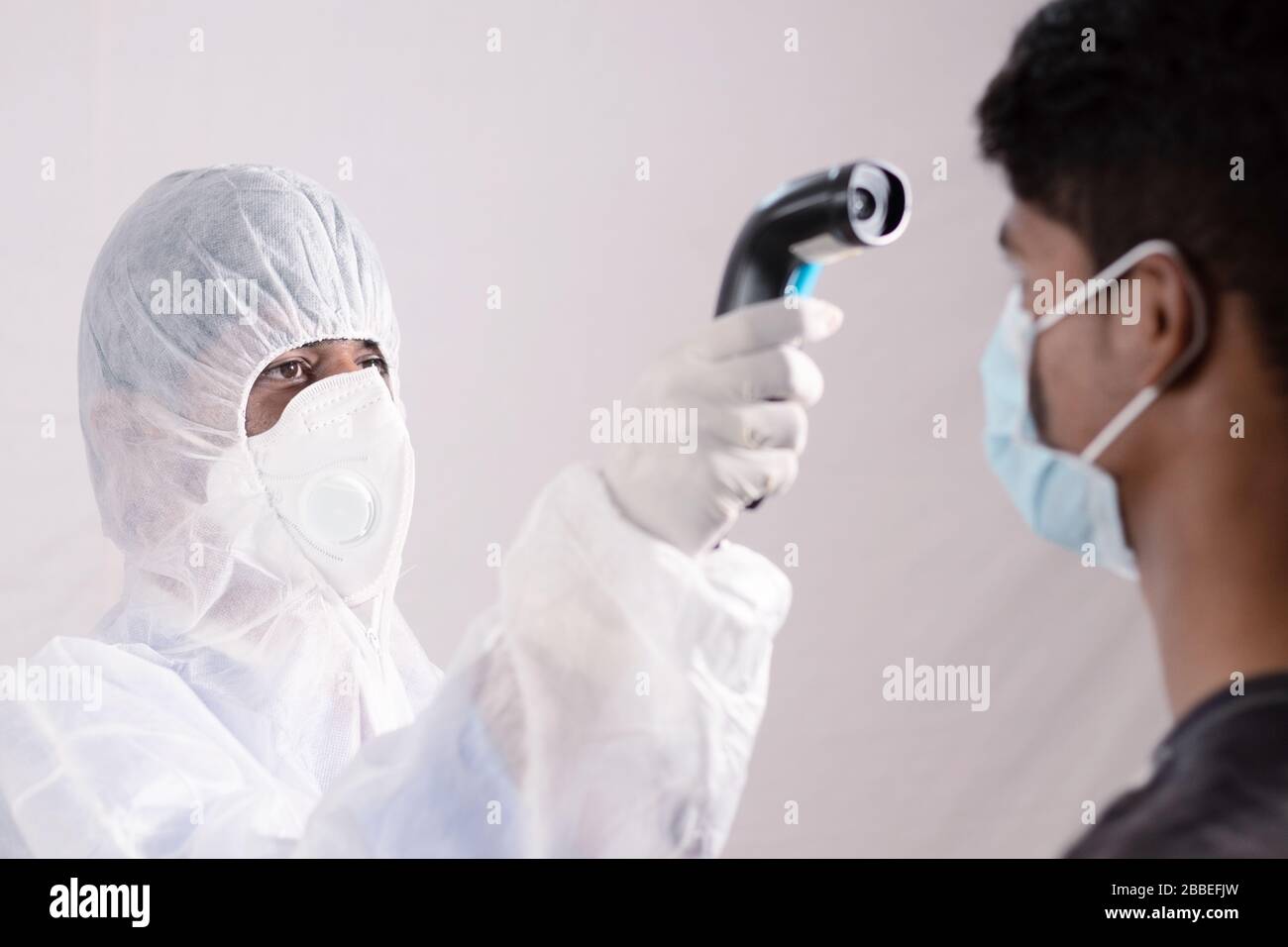 Epidemiologe überprüfen Fieber mit Digitalthermometer am Krankenhauszähler auf Scan und Schutz vor Coronavirus- oder COVID-19-Ausbruch. Rasterpunkt für Stockfoto