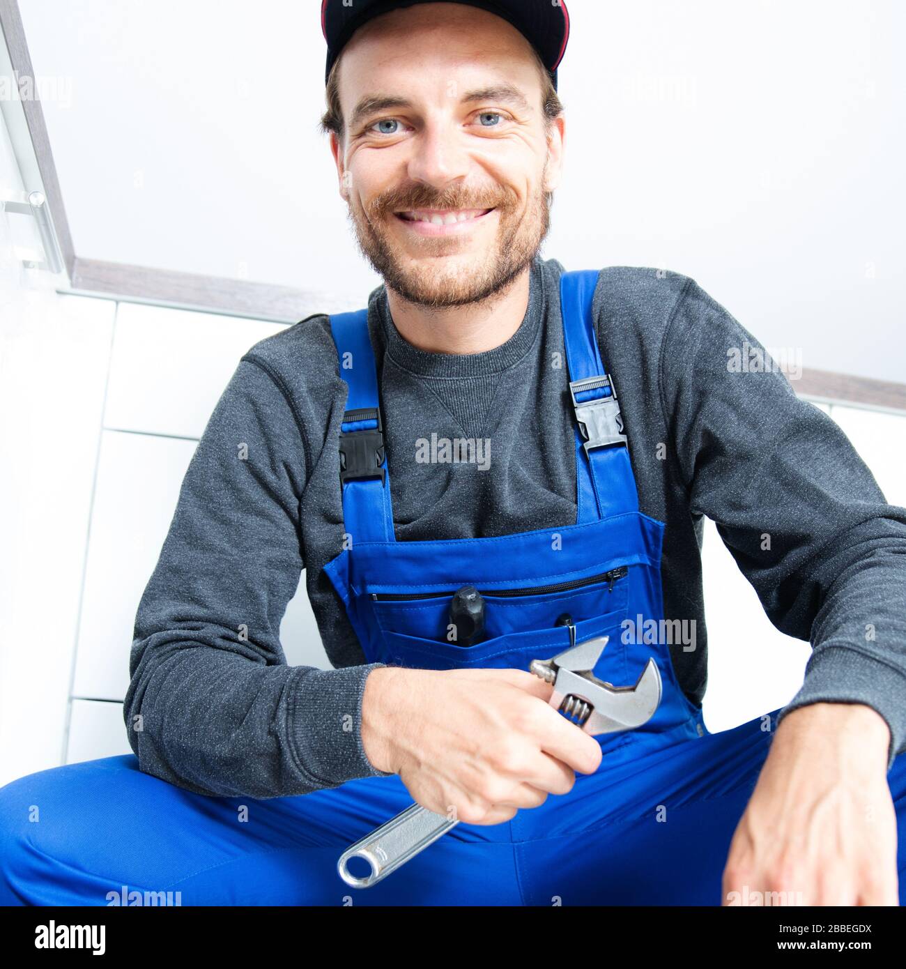Installateur mit einem Rohrschlüssel bei der Arbeit Stockfoto