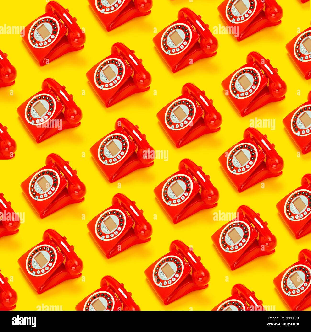 Ein rotes Retro-Telefon vor gelbem Hintergrund. Stockfoto